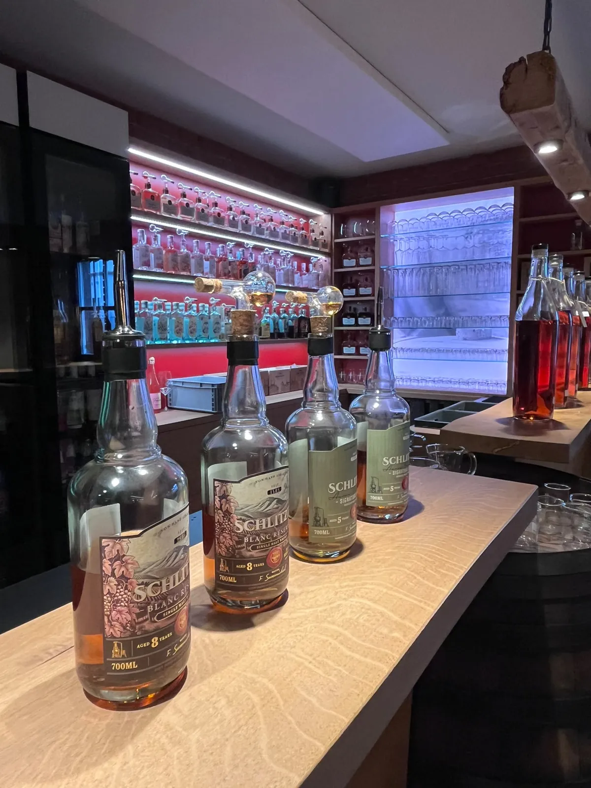Bar der Schlitzer Destillerie mit Schlitzer Whisky-Flaschen und beleuchtetem Spirituosenregal