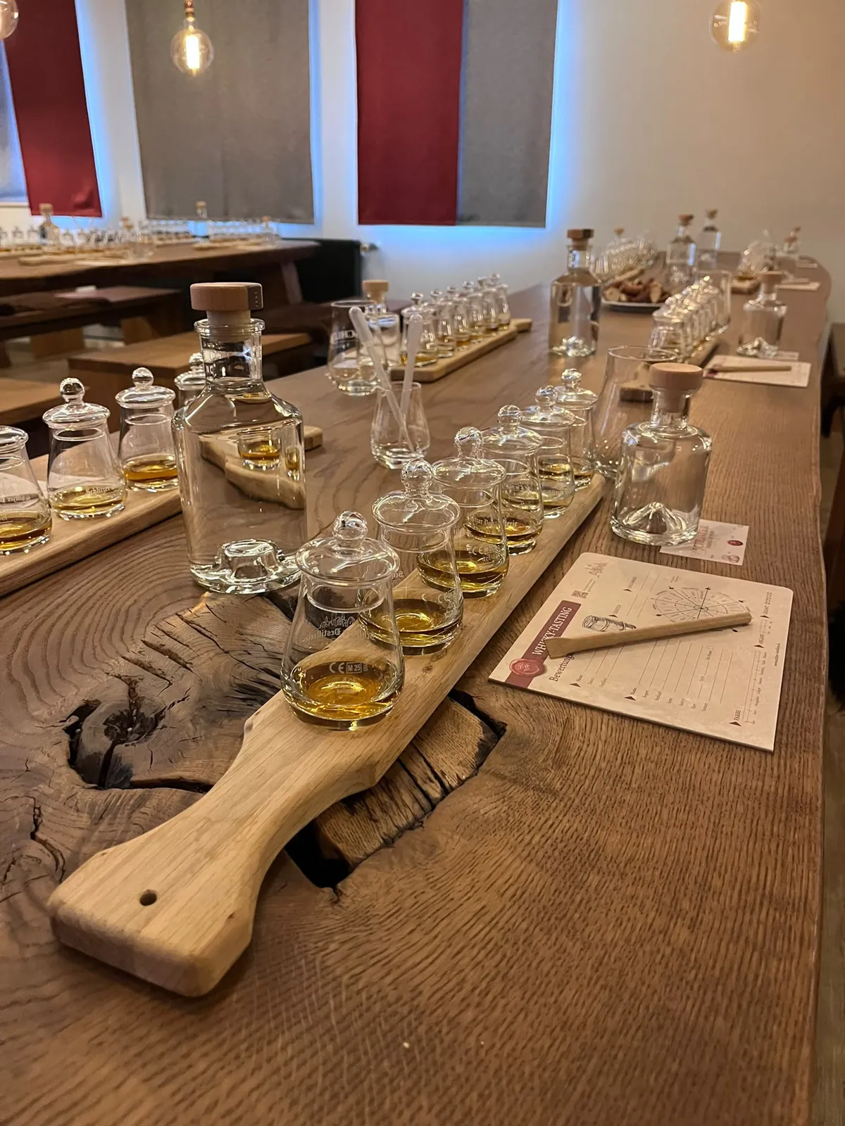 Tasting-Brett aus Eiche mit gefüllten Nosing-Gläsern, Glasdeckeln und Whisky-Tasting-Bewertungsbogen mit Aromarad