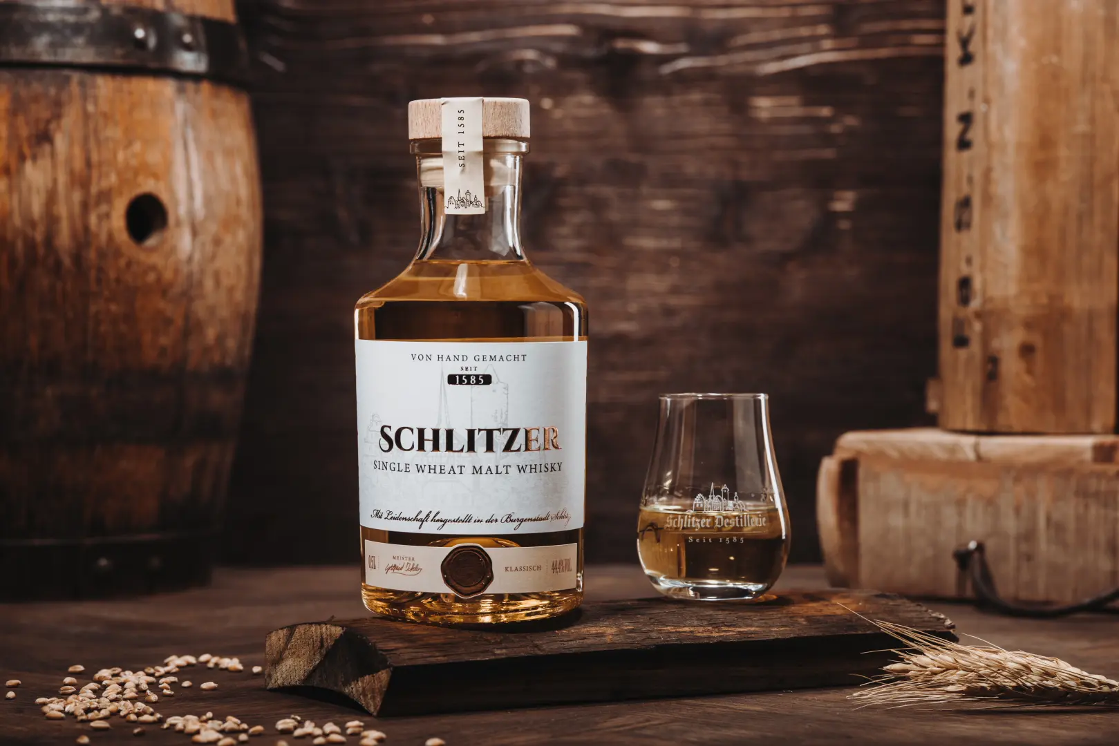 Single Wheat Malt Whisky – Schlitzer Destillerie Flasche vor hellem Hintergrund Flasche Schlitzer Single Wheat Malt Whisky vor weißem Hintergrund – deutscher Weizenwhisky in schlanker Glasflasche mit schwarzem Etikett und goldenen Akzenten.