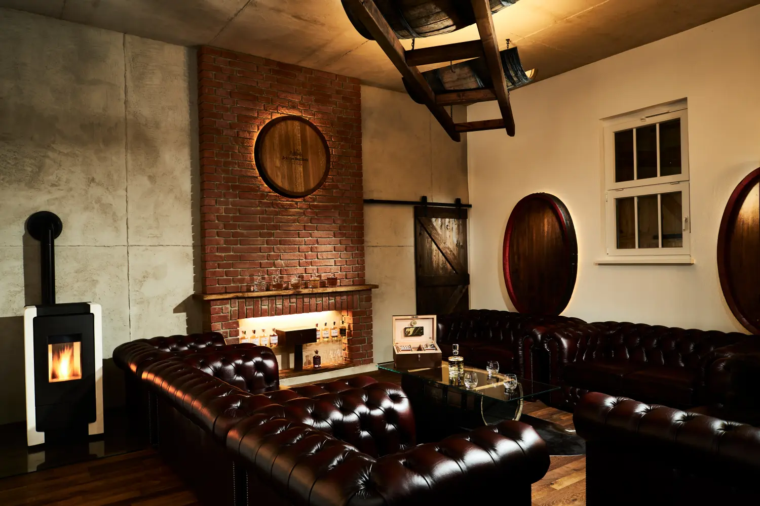 Whisky Lounge der Schlitzer Destillerie mit stilvoller Bar und gemütlichem Ambiente Moderne Whisky Lounge der Schlitzer Destillerie mit stilvollen Ledersesseln, warmem Licht, Holzboden und Regalen voller edler Spirituosen in historischem Ambiente