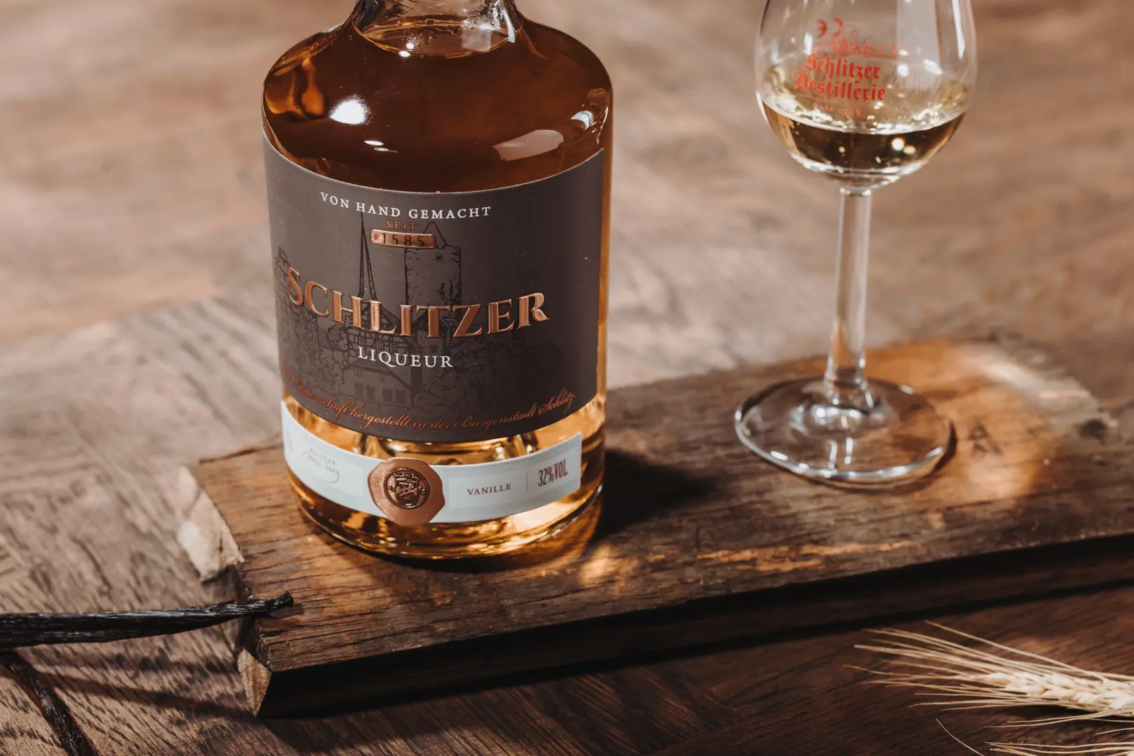 Stimmungsvolle Whisky-Präsentation bei Schlitzer Destillerie Ein stilvolles Arrangement mit Whiskyflaschen der Schlitzer Destillerie auf einem dunklen Holztisch, umgeben von edlen Gläsern und sanfter Beleuchtung, betont die hochwertigen Spirituosen aus Deutschland.