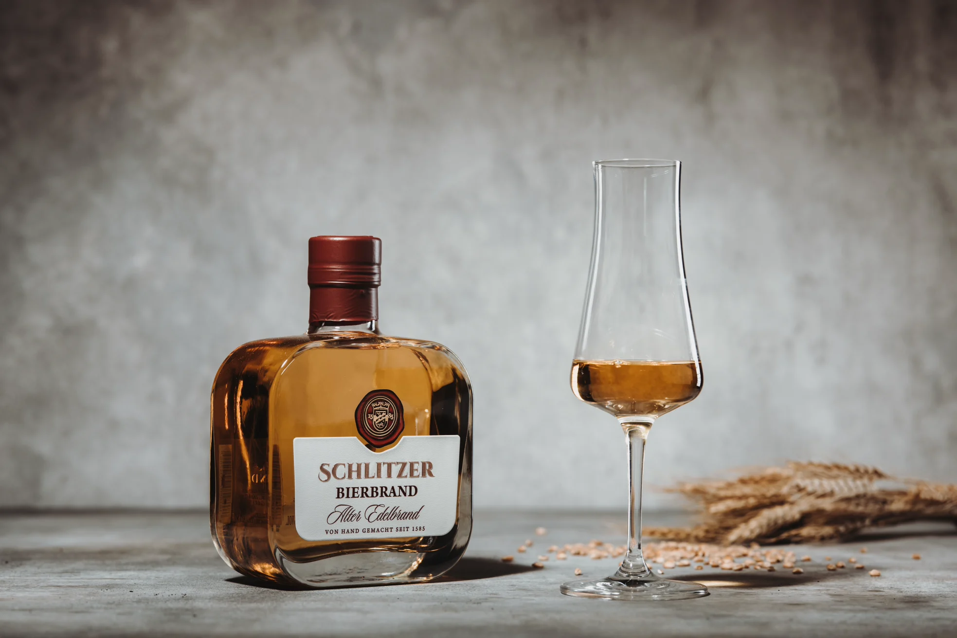 Bierbrand in edler Flasche aus der Schlitzer Destillerie – Hochwertiger deutscher Edelbrand Flasche Schlitzer Bierbrand auf hellem Hintergrund, goldfarbene Flüssigkeit mit edlem Etikett, Produkt der Schlitzer Destillerie für Genießer hochwertiger Spirituosen.