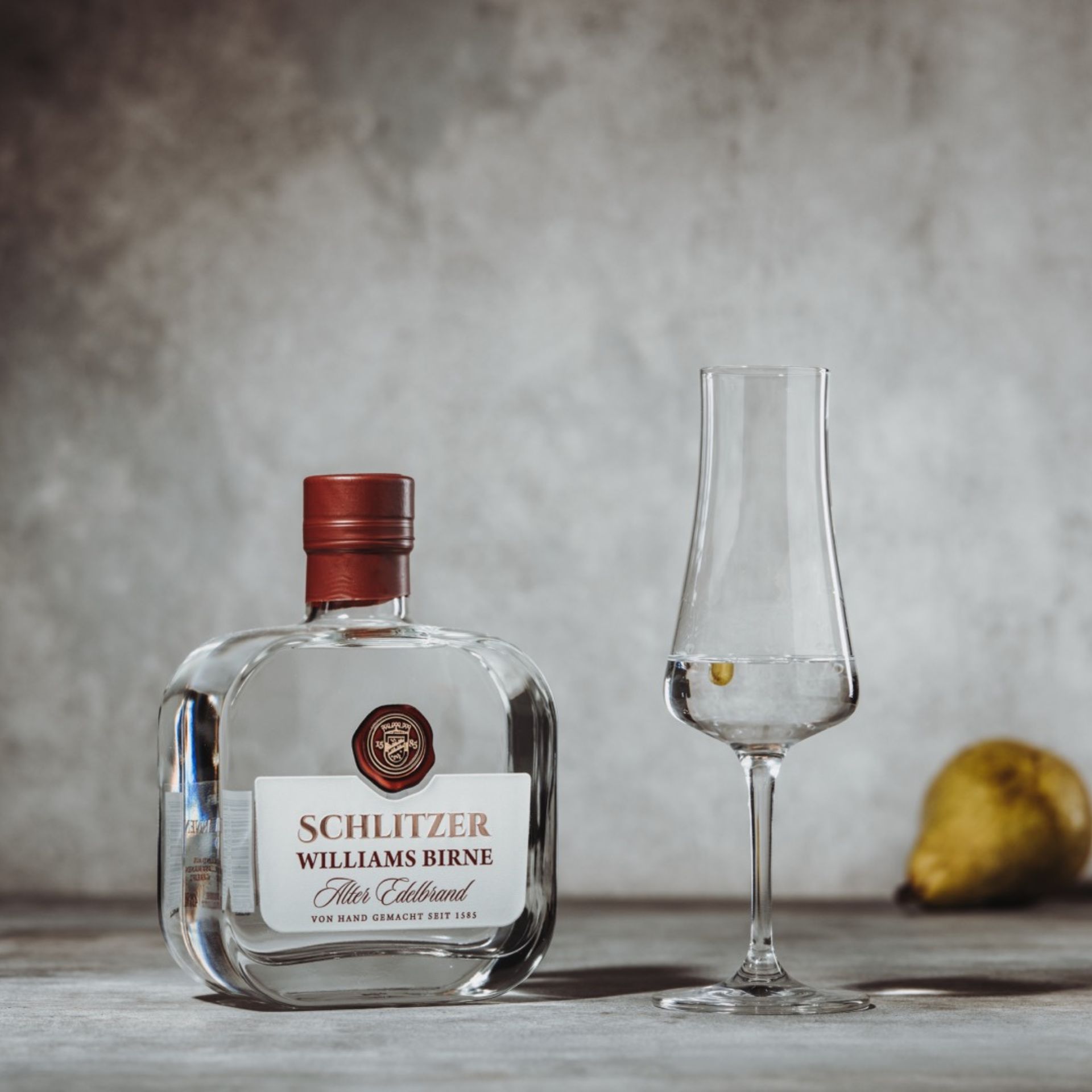 Alter Williams Birnenbrand – Edler Obstbrand aus vollreifen Williams-Christ-Birnen Klare Glasflasche des Alten Williams Birne Brandes von der Schlitzer Destillerie mit goldener Verschlusskappe, edlem Etikett in Beige und Gold sowie sichtbarem Birnenmotiv – hochwertiger Birnenbrand aus traditioneller Herstellung.