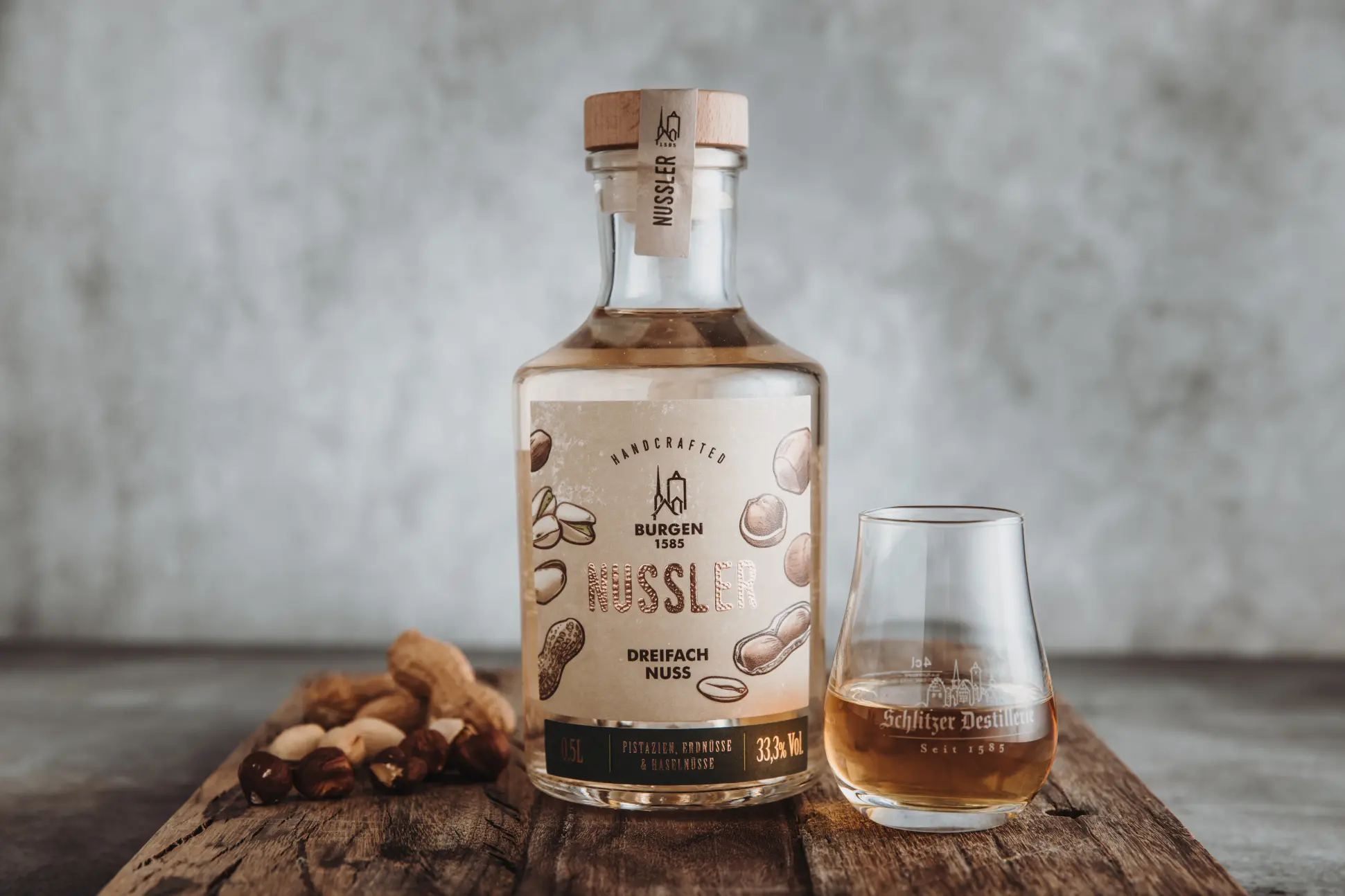 Schlitzer Haselnuss Schnaps – Edler Nussler Likör in hochwertiger Flasche Flasche Schlitzer Haselnuss Schnaps Nussler mit braunem Etikett und goldenem Verschluss vor weißem Hintergrund – hochwertiger Haselnusslikör aus der Schlitzer Destillerie