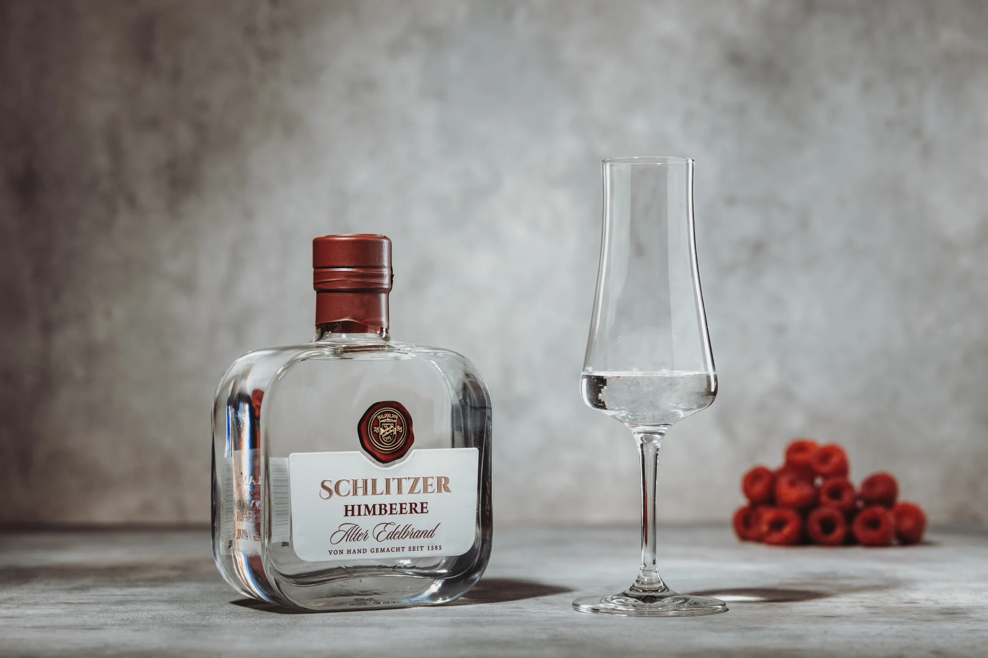 Flasche Schlitzer Alter Himbeer-Brand mit goldfarbenem Etikett auf weißem Hintergrund – hochwertige Spirituose aus Himbeeren, hergestellt in der Schlitzer Destillerie.
