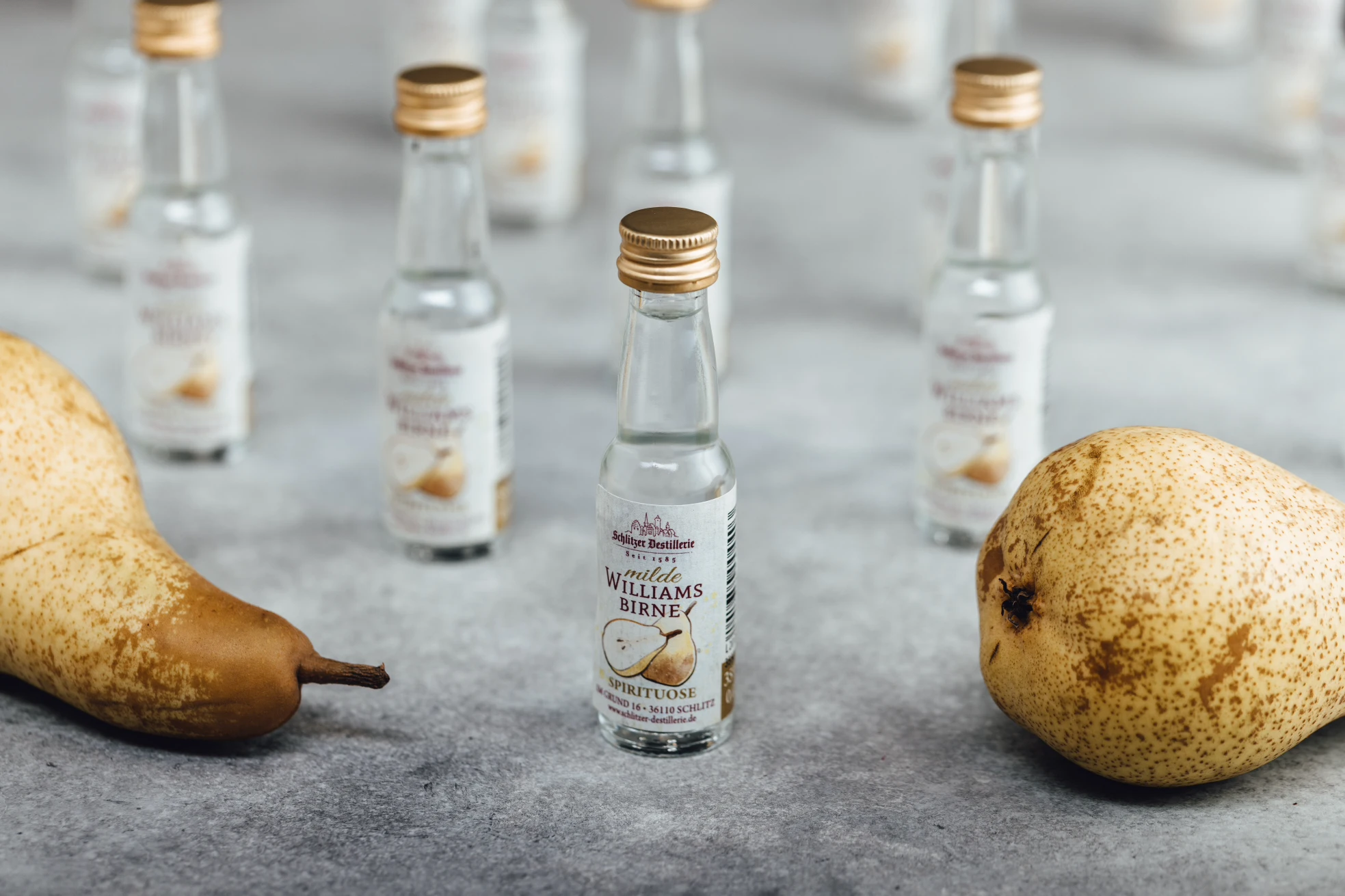 Milder Spirituosen Mix – Hochwertige Auswahl von Schnaps und Likör aus der Schlitzer Destillerie Verschiedene milde Spirituosen in stilvollen Flaschen auf einem Holztisch arrangiert, ideal für Aperitifs und Cocktails – Sortiment der Schlitzer Destillerie für Genießer.