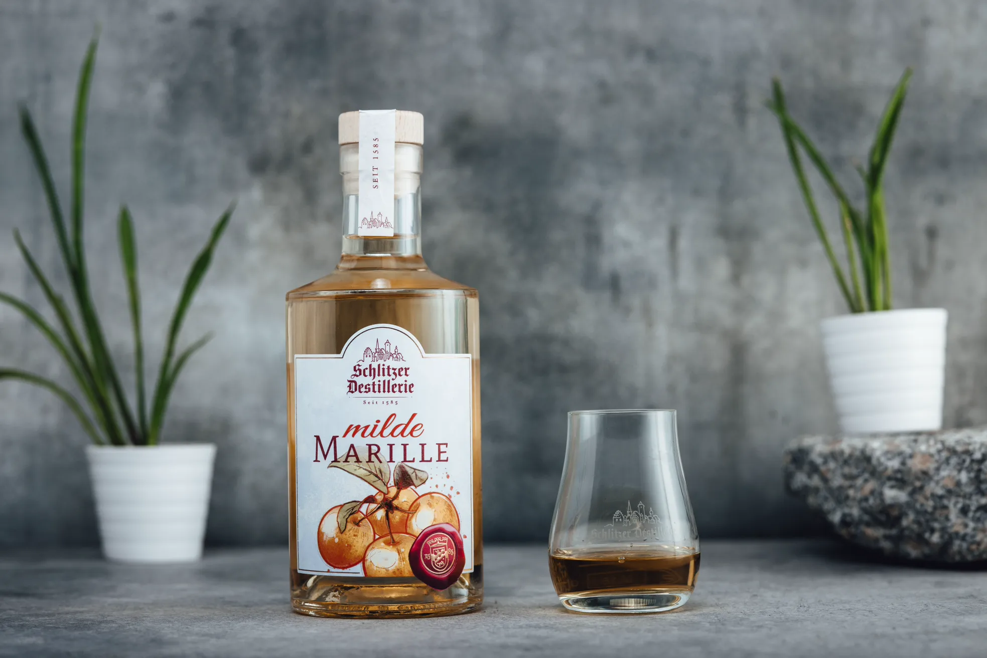 Schlitzer Marille Schnaps – Fruchtiger Aprikosenschnaps in eleganter Flasche Flasche Schlitzer Marille Schnaps mit goldfarbenem Etikett, stehend vor weißem Hintergrund – Obstbrand aus Marillen, hessische Spezialität der Schlitzer Destillerie.
