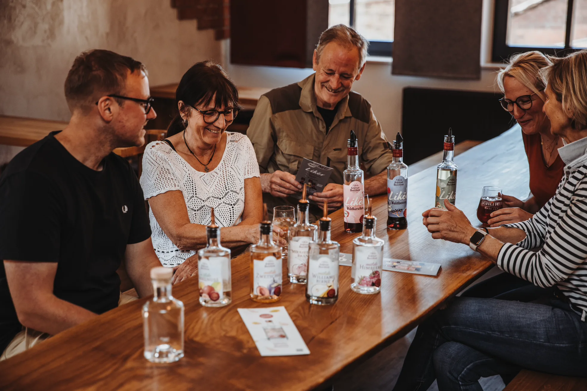 Führung durch die Schlitzer Destillerie mit historischen Brennkesseln Zwei Besucherinnen in historischen Gewölben der Schlitzer Destillerie betrachten hölzerne Fässer; Führung durch traditionelle Brennerei im Vogelsberg, Hessen.
