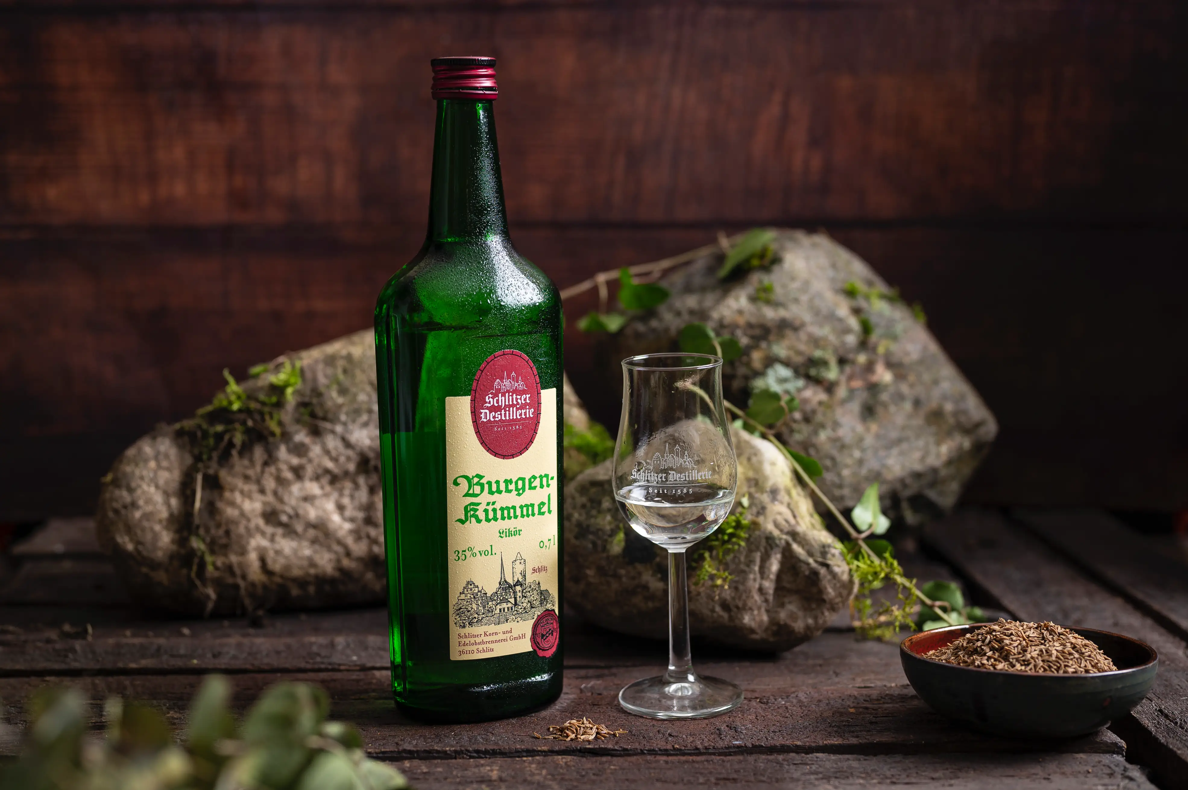 Schlitzer Kümmel Likör – Edler Kümmellikör aus Hessen in der 0,5 l Flasche Flasche Schlitzer Kümmel Likör mit Etikett in Weiß und Gold auf hellem Hintergrund – traditioneller Kräuterlikör aus der Schlitzer Destillerie in Deutschland.