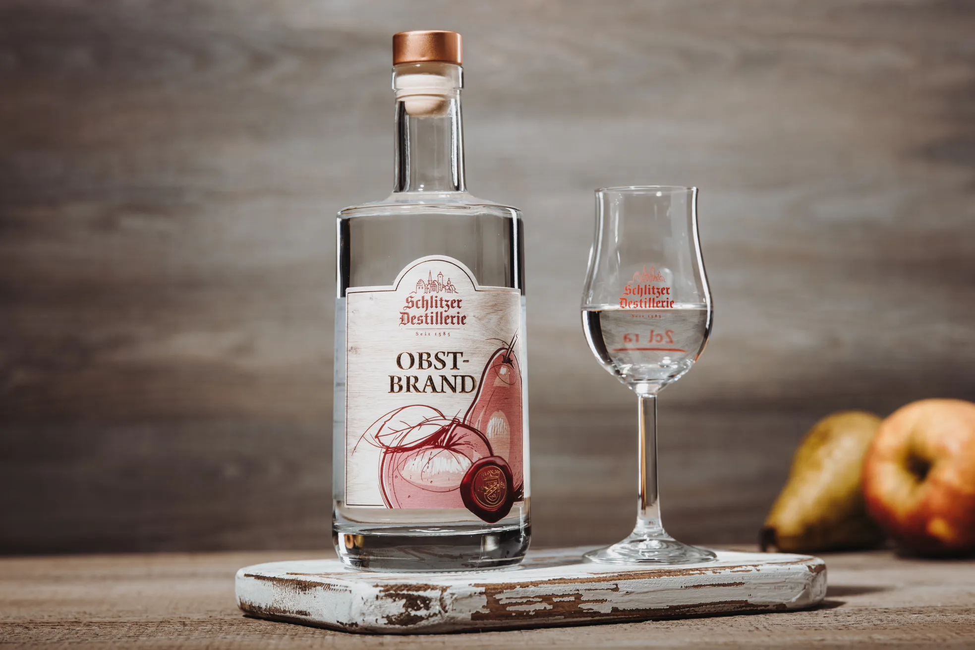 Obstbrand in edler Flasche – Premium-Destillat der Schlitzer Destillerie Flasche Schlitzer Obstbrand vor weißem Hintergrund – klarer Edelbrand aus der Schlitzer Destillerie mit elegantem Etikett und Holzkorken, hochwertiger deutscher Obstbrand für Genießer.