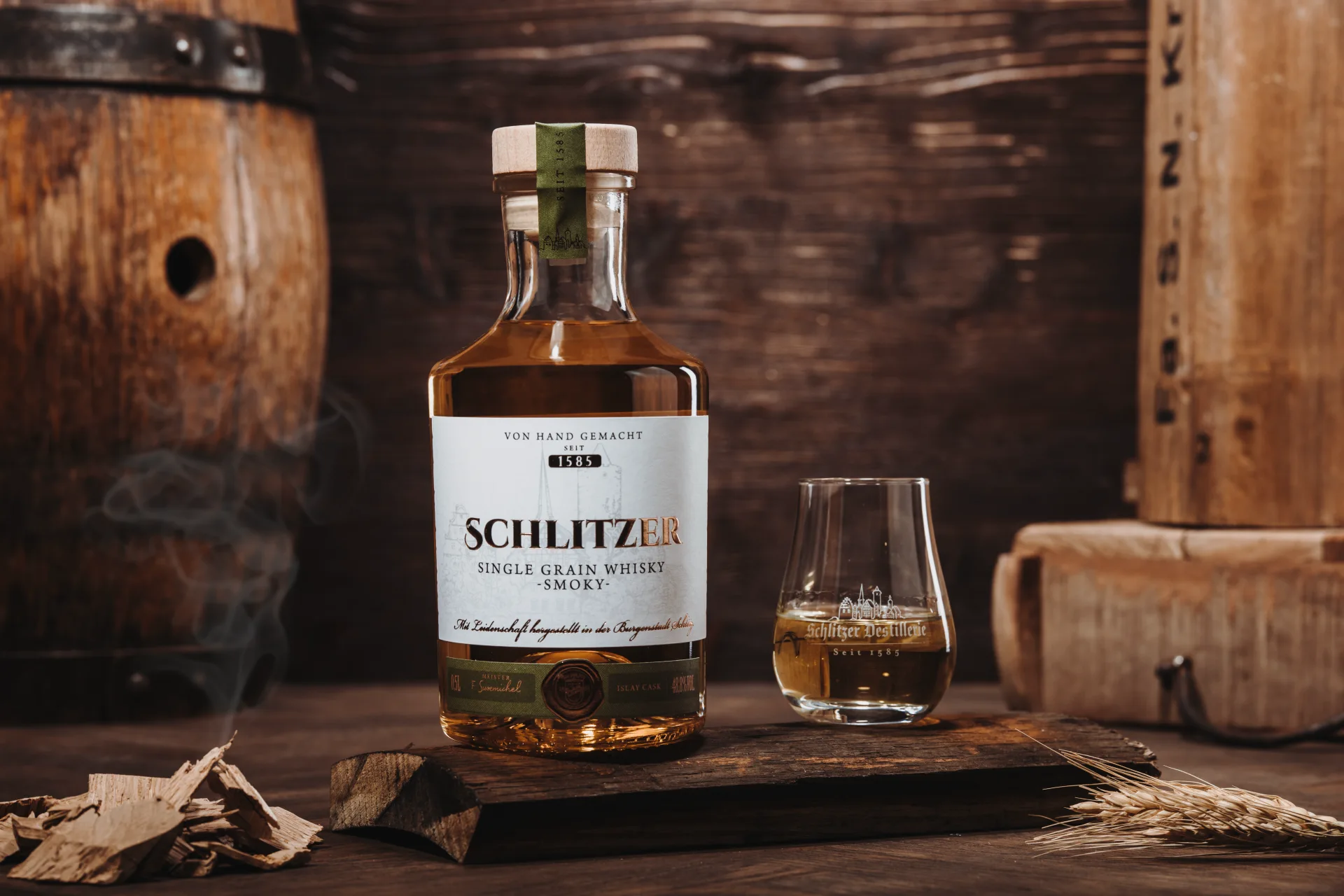 Schlitzer Single Malt Whisky Smoky – Rauchiger deutscher Whisky in limitierter Edition Flasche Schlitzer Single Malt Whisky Smoky mit Etikett in dunklem Design, auf holzgemasertem Hintergrund, betont rauchig-torfiger Charakter des deutschen Whiskys.