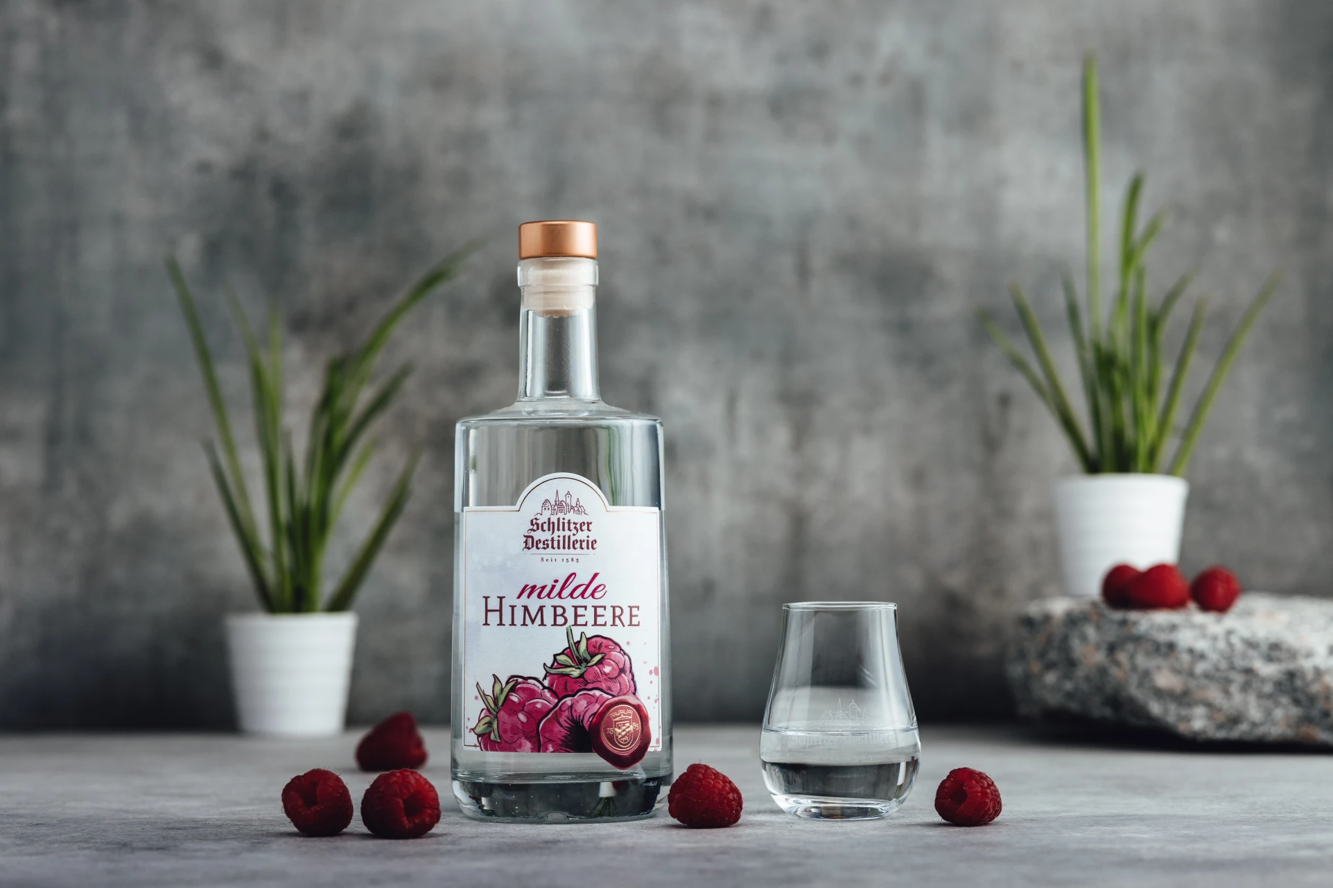 Milde Himbeere Spirituose – Fruchtiger Genuss aus der Schlitzer Destillerie Flasche Milde Himbeere Spirituose von der Schlitzer Destillerie mit rotem Etikett, auf weißem Hintergrund, alkoholarmer Fruchtbrand mit Himbeergeschmack, 0,5 Liter.