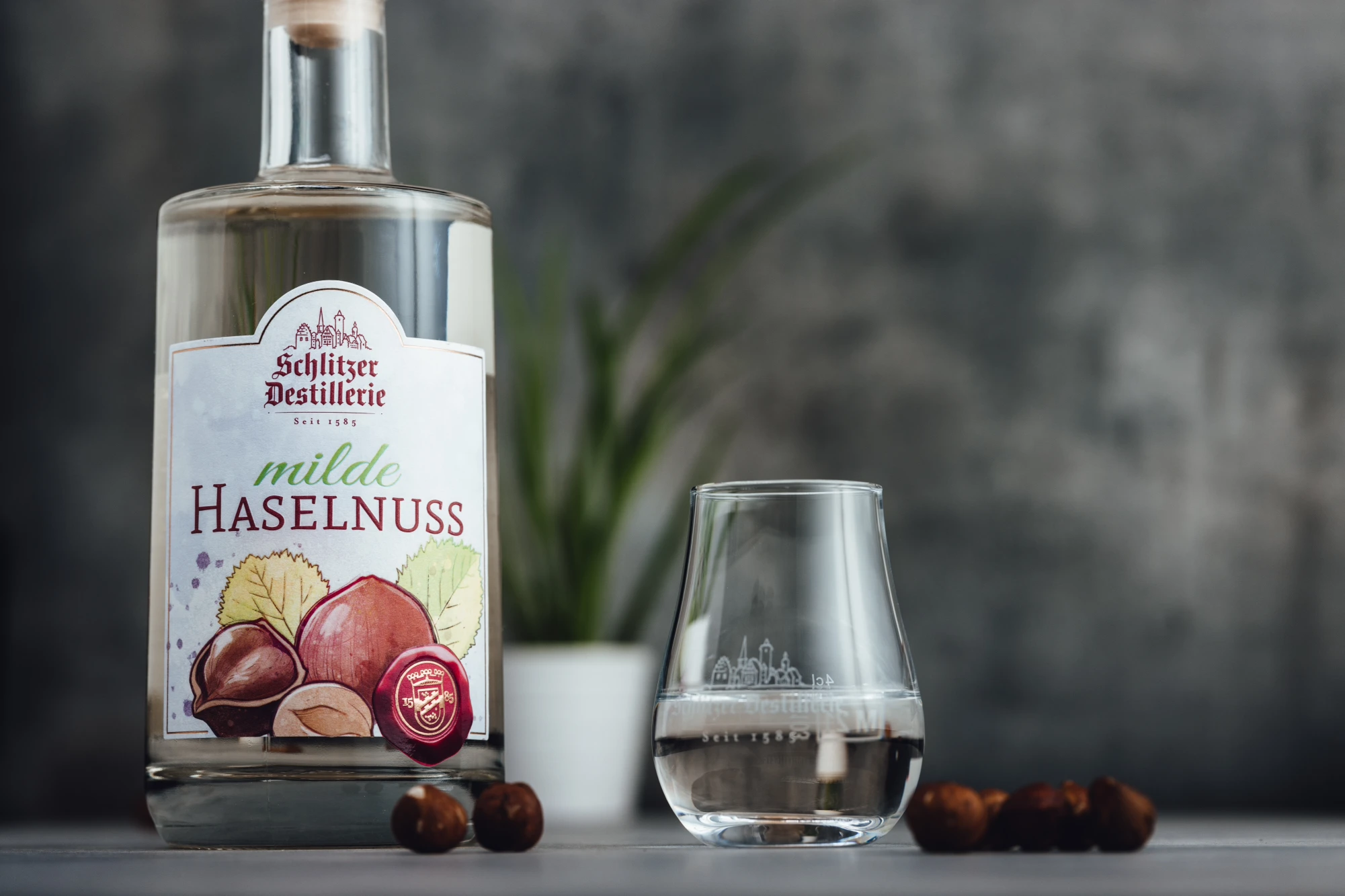 Haselnuss Schnaps in edler Flasche vor neutralem Hintergrund – Schlitzer Destillerie Flasche Schlitzer Haselnuss-Schnaps mit braunem Etikett auf weißem Hintergrund – edler Nusslikör aus der Schlitzer Destillerie in Deutschland