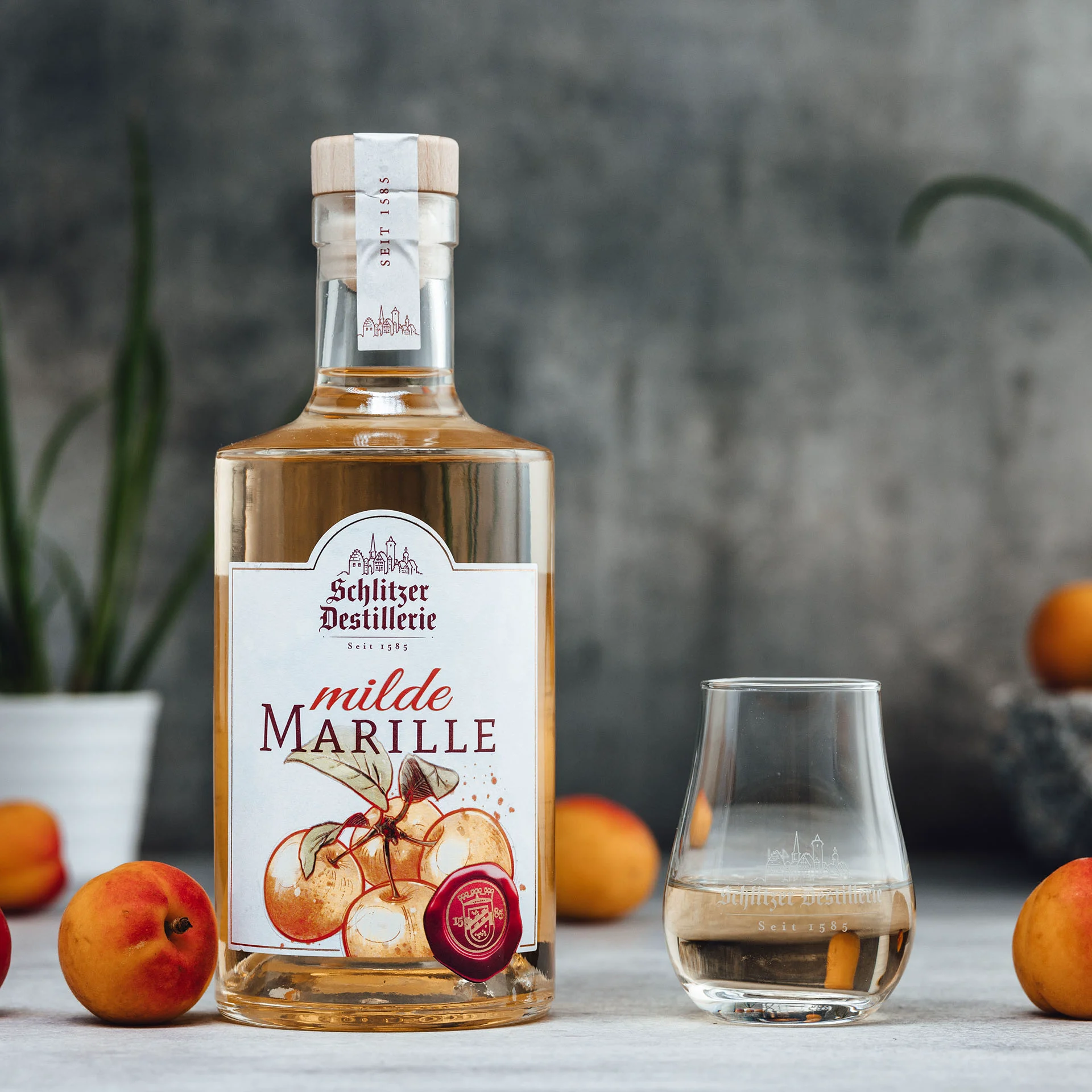 Marille Schnaps in edler Flasche – Fruchtiger Obstbrand der Schlitzer Destillerie Flasche Schlitzer Marille Schnaps auf weißem Hintergrund – Edelobstbrand aus Marillen (Aprikosen) in klarer Glasflasche mit Etikett der Schlitzer Destillerie.