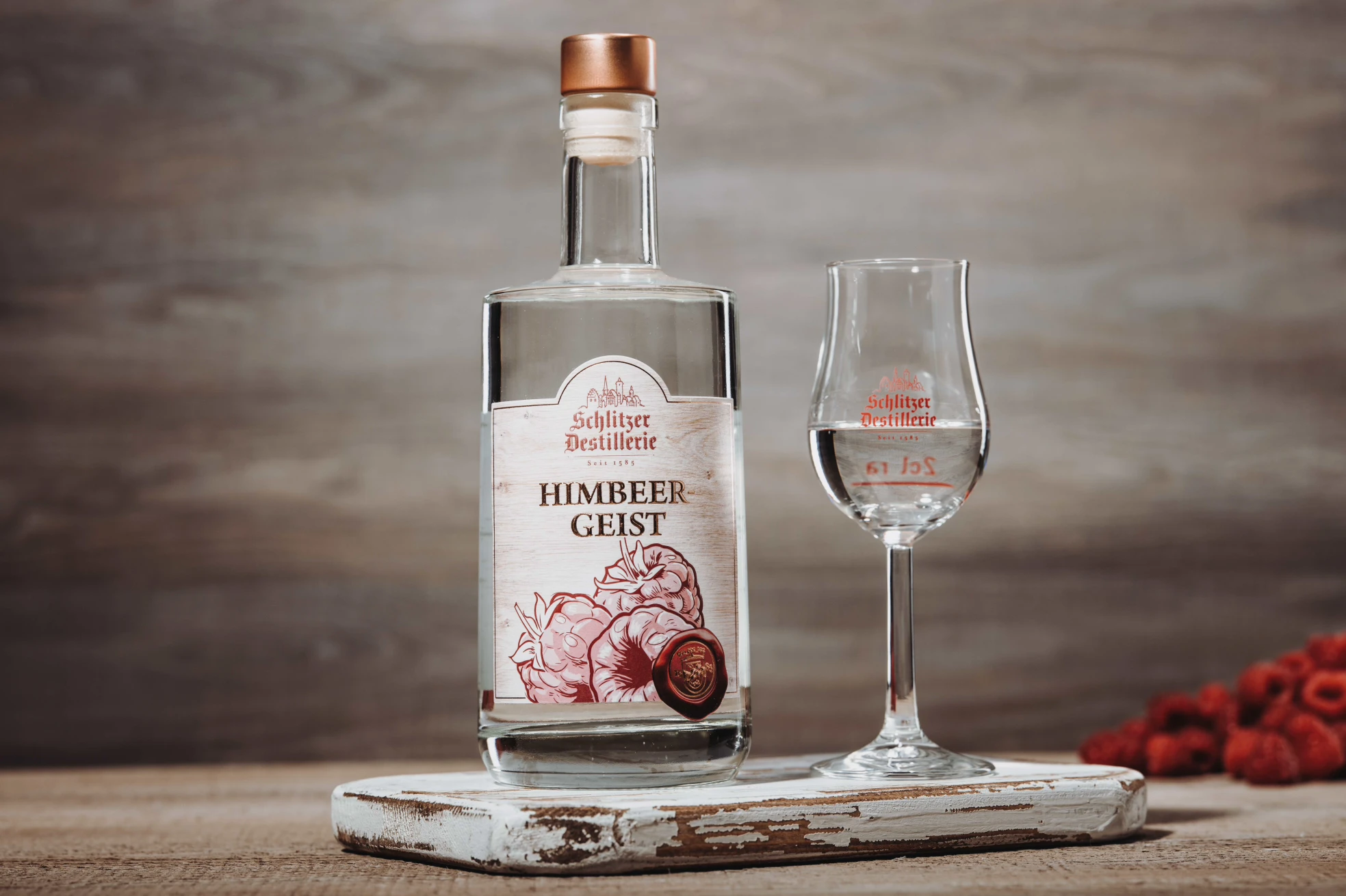 Himbeergeist aus Hessen in edler Glasflasche – Feinbrennerei Schlitzer Destillerie Klare Glasflasche Schlitzer Himbeergeist aus Hessen mit rotem Etikett und silberner Verschlusskapsel, vor weißem Hintergrund – traditioneller Fruchtbrand aus frischen Himbeeren.