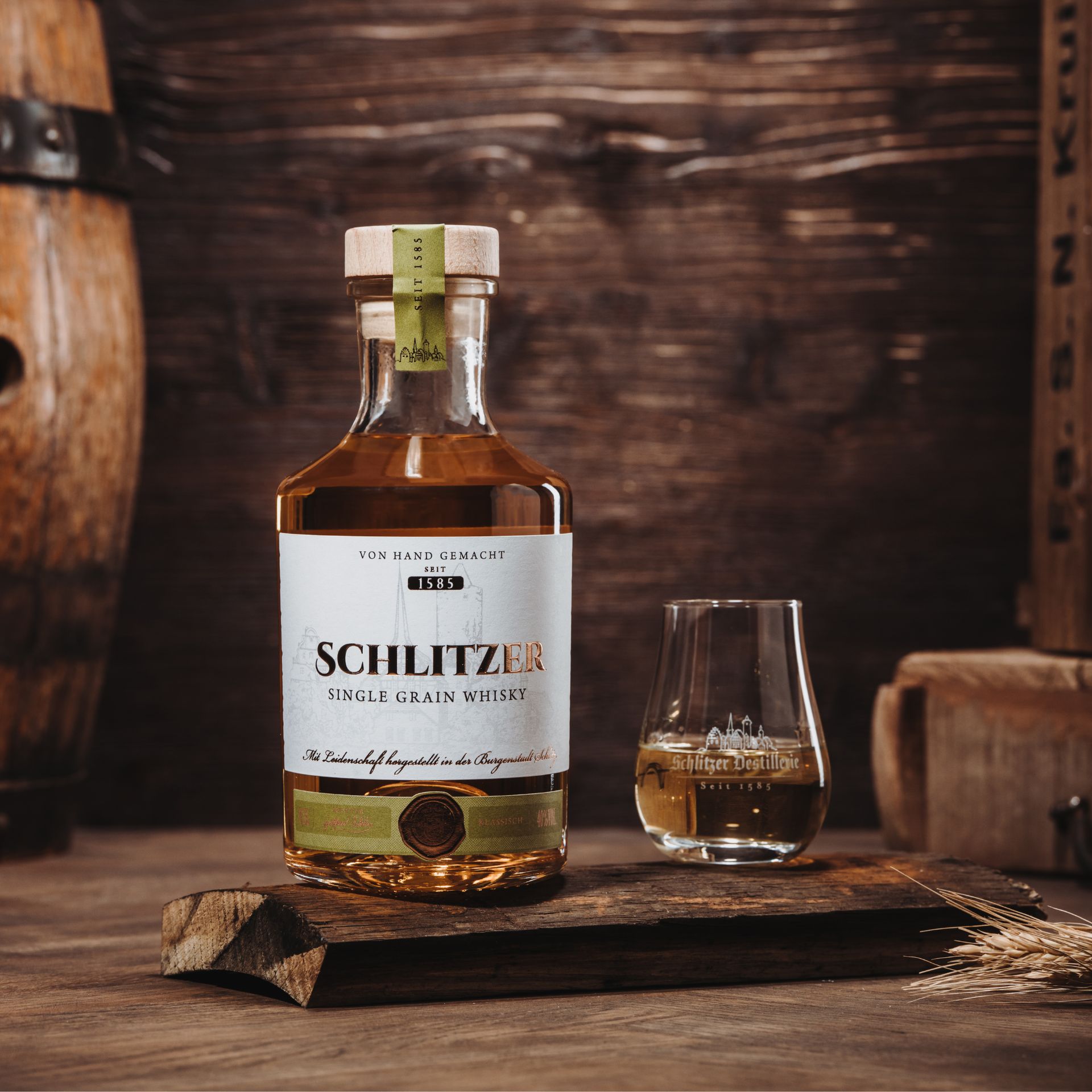 Schlitzer Single Grain Klassisch – Deutscher Whisky in edler Flasche Flasche Schlitzer Single Grain Whisky Klassisch vor weißem Hintergrund, mit goldfarbenem Etikett und schwarzem Verschluss – deutscher Premium-Whisky aus der Schlitzer Destillerie.