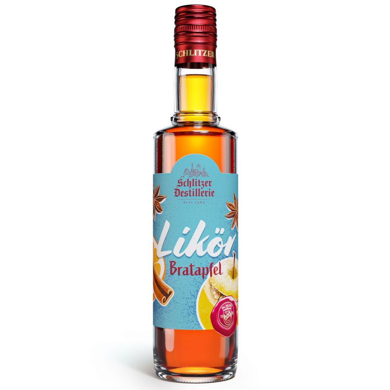 Flasche Schlitzer Bratapfellikör mit rotem Etikett und Apfel-Zimt-Motiv vor weihnachtlicher Dekoration aus Zimtstangen, Äpfeln und Tannenzweigen auf rustikalem Holztisch.