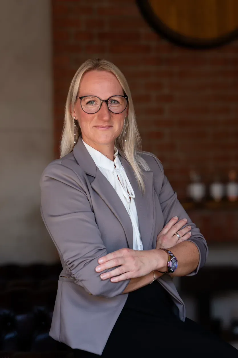 Jennifer Hartung, Vertriebsmitarbeiterin Gastronomie der Schlitzer Destillerie, im Portrait vor einem Regal mit Spirituosen